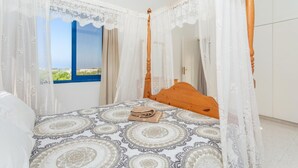 A four-poster bed with a patterned bedspread, a wooden headboard, and a canopy. - Villa Charoula Tria Large Private Pool, A/C, WiFi (Polis)