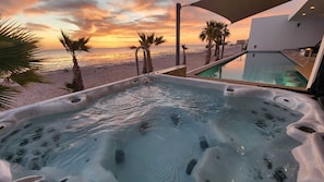 Een hottub met uitzicht op het strand en de zonsondergang.