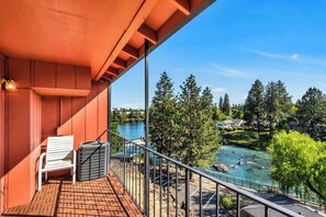 A balcony with a view of a river, trees, and houses. - Third-floor riverfront condo near downtown Bend (Bend)