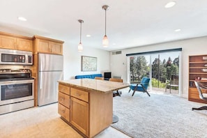 A modern kitchen with wooden cabinets, stainless steel appliances, and a central island.
