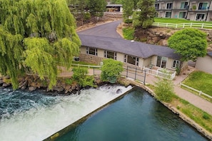 Un hôtel situé au bord de la rivière, avec une façade en pierre, un pont et une vue sur le fleuve.