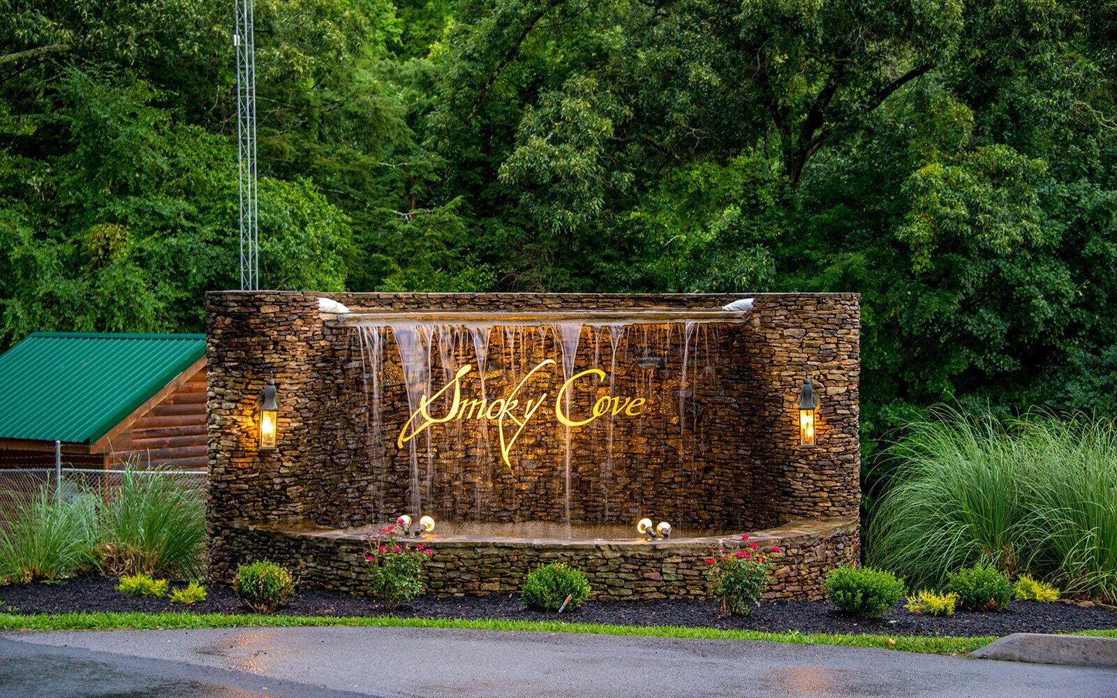 Un mur de pierre avec une cascade, et les mots « Smoky Cove » illuminés au centre.