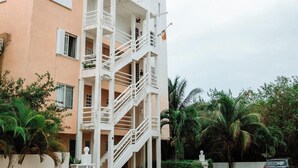 Ein mehrstöckiges Gebäude mit Balkonen und einer Treppe.