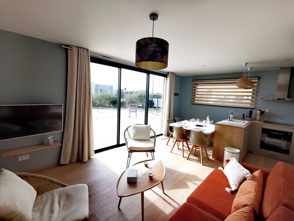 Relax in this inviting living space with a large flat-screen TV, dining area, and comfortable seating.