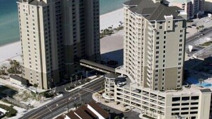 A high-rise hotel with multiple floors, a parking garage, and a beach view.