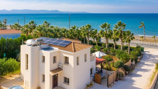 A modern building with solar panels, a pool, and a view of the sea. - Villa Jan Lui - Four Bedroom Villa, Sleeps 8 (Argaka)