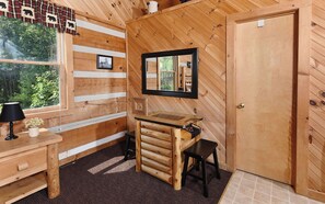 Cozy retreat with a wooden desk, mirror, and window offering a view of the outdoors.