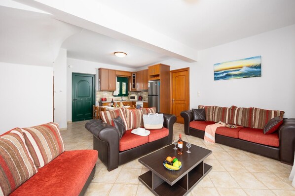 A modern living room with two sofas, a coffee table, and a kitchen in the background.