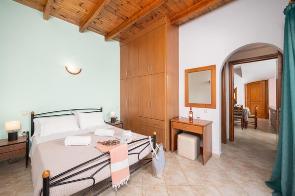 Un dormitorio con cama, armario de madera, mesita de noche y espejo.