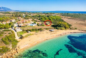 An aerial view of a coastal resort with villas, a beach, and clear blue waters. - Antigoni Beach House (Vrahinari Beach)