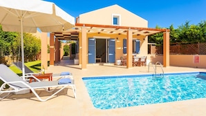 A pool area with lounge chairs and a pergola.