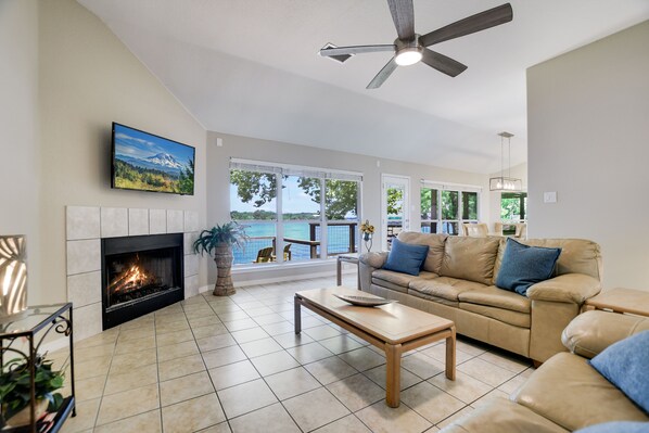A living room with a fireplace, a sofa, a coffee table, and a TV mounted on the wall.