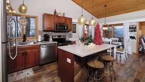 Una cocina moderna con armarios de madera, electrodomésticos de acero inoxidable y una isla grande con taburetes.