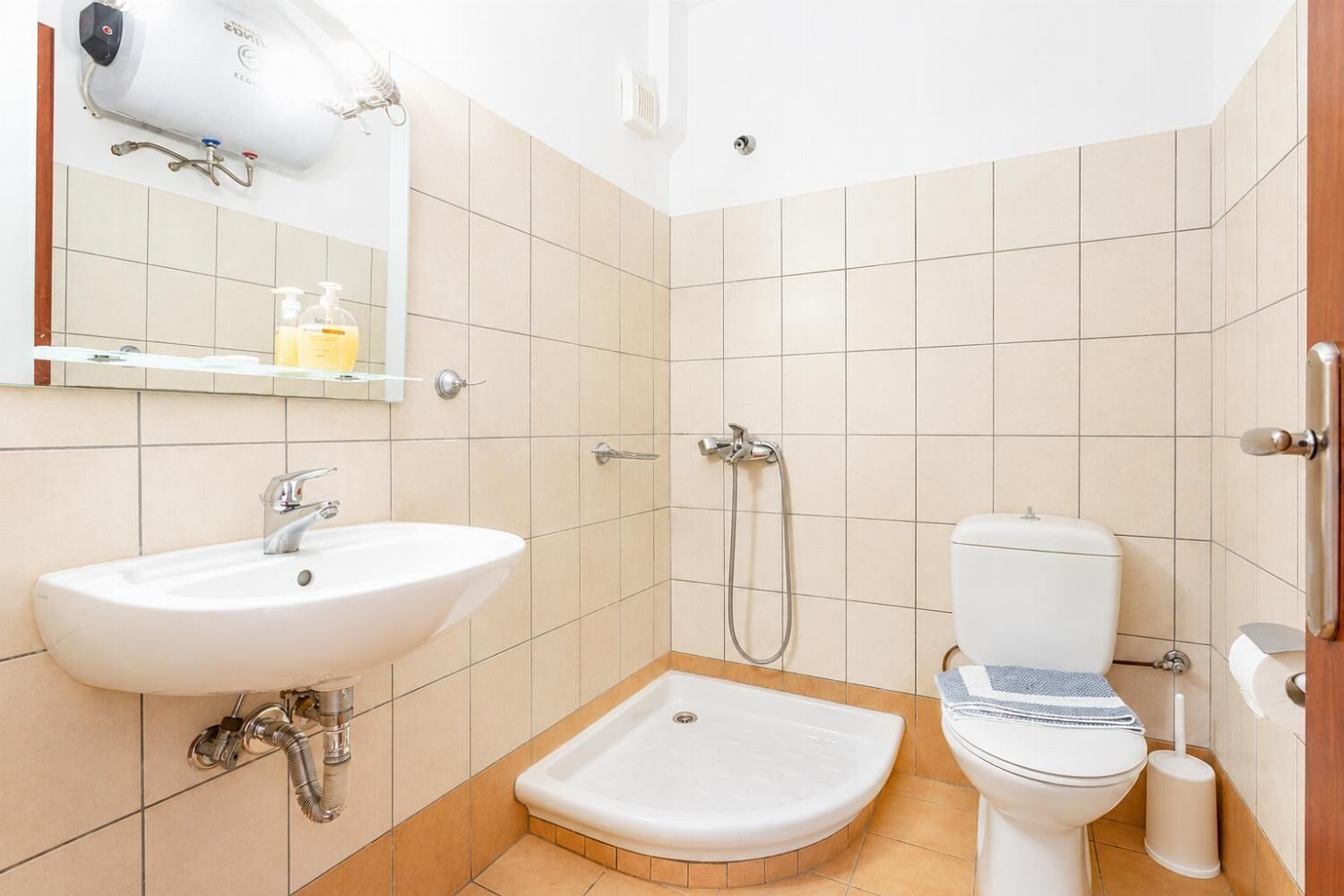 A bathroom with a sink, toilet, and shower.