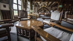 A library with wooden furniture, large windows, and bookshelves. - Posada la Ermita (San Miguel de Allende)