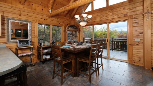 L’intérieur d’une cabane en bois comprend un coin repas, une cuisine et de grandes fenêtres.