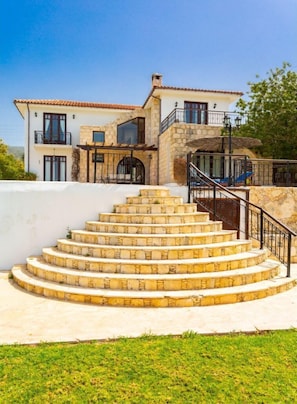 Ein mehrstöckiges Haus mit einer Steintreppe, die zu einem Balkon führt.