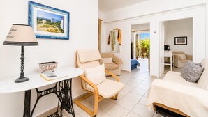 Un soggiorno moderno con un divano, una poltrona, un tavolo, una lampada e un quadro incorniciato appeso al muro.