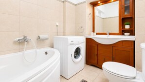 Un bagno moderno con una vasca, una lavatrice e un water.