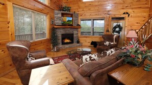 A cozy cabin interior with a fireplace, leather furniture, and a Christmas wreath. - Hemlock Ridge 1713 - Mountain View from Hot Tub (Gatlinburg)