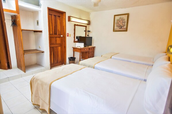 A hotel room with two beds, a wooden wardrobe, a desk with a television, and a framed picture on the wall. - Hotel Santa Lucía (Mérida)