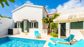 A pool area with a clear blue pool, two lounge chairs, and a covered umbrella. - Villa Torreta - Three Bedroom Villa, Sleeps 4 (Punta Prima)