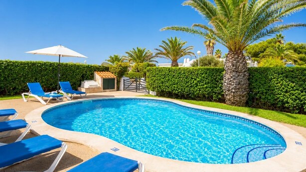 Piscina con sillones de descanso y zona de barbacoa.