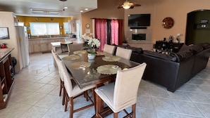 A modern kitchen with a dining area, a living room with a sofa, and a TV mounted on the wall. - Casa Milan 3BR/5Beds-LaQuinta Hm Lic.065016 (La Quinta)