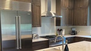 Una cocina moderna con armarios de madera oscura, electrodomésticos de acero inoxidable y encimera de mármol.