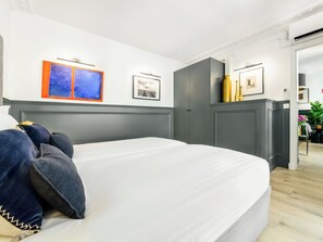 Quarto moderno com uma cama grande, cabeceira cinza e ar condicionado fixado na parede.