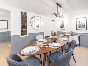 Enjoy meals with family and friends at this dining area, featuring a long table and six comfortable chairs.