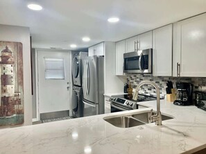 A modern kitchen with stainless steel appliances, a microwave, and a sink.