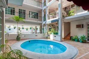 A multi-level indoor swimming pool with balconies, potted plants, and a staircase. - Boca Inn Hotel and Suites (Boca del Río)