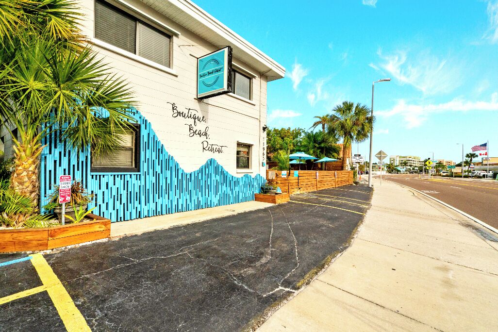 Um edifício com uma placa que diz 'Boutique Beach Retreat' e fachada azul.