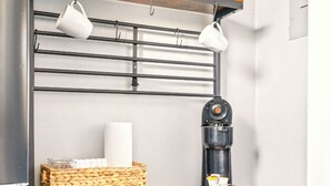 A kitchen with a coffee machine, a bread box, and a knife block.