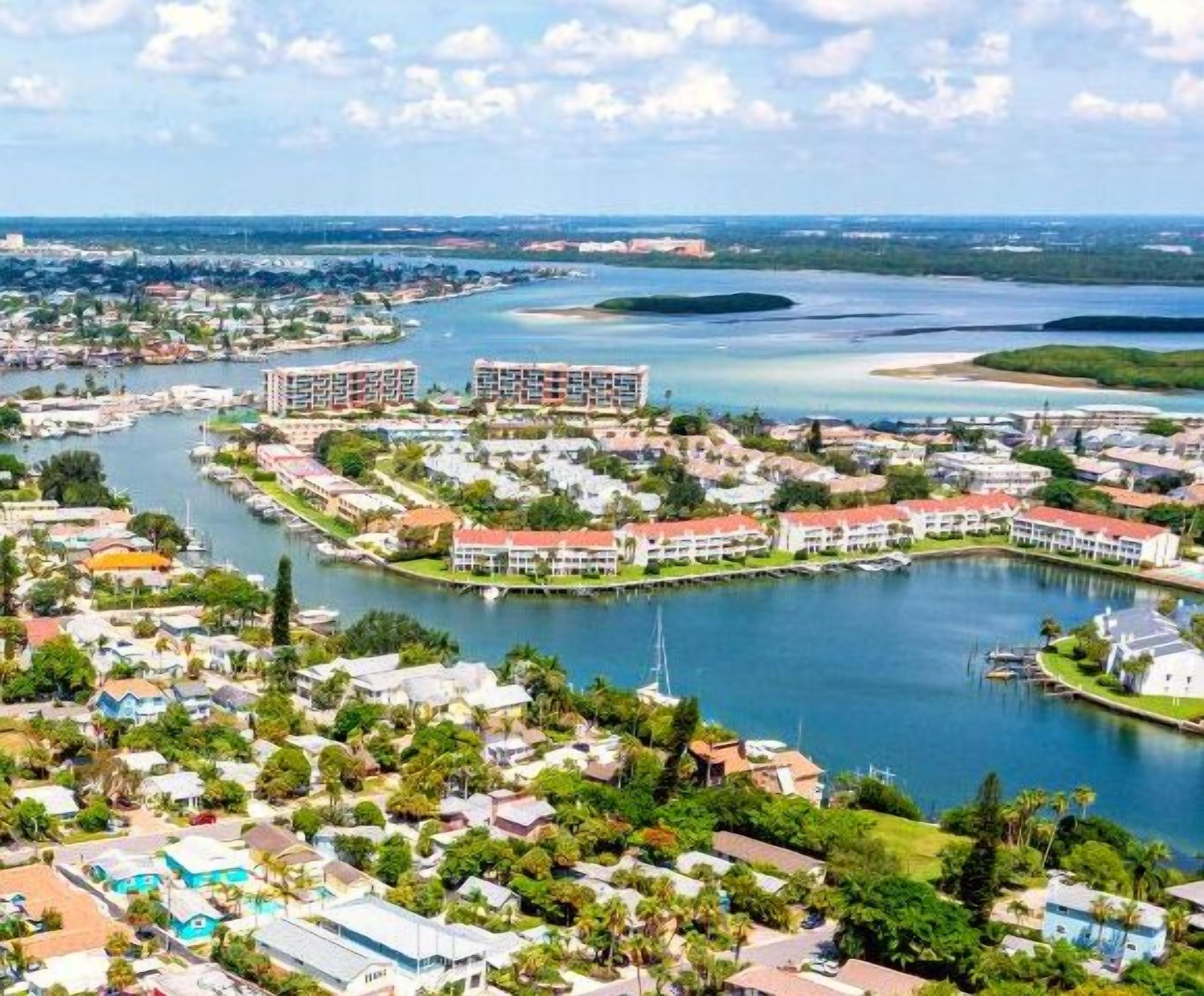 A coastal resort with multiple buildings, a marina, and surrounding greenery.