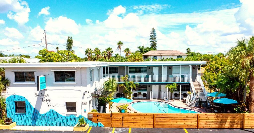 A two-story building with a pool, named 'Boutique Beach Retreat'.