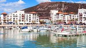 A marina with boats docked, surrounded by multi-story buildings with balconies, under a clear sky. - Atlantic Palm Beach Aparthotel 5170 (Agadir)