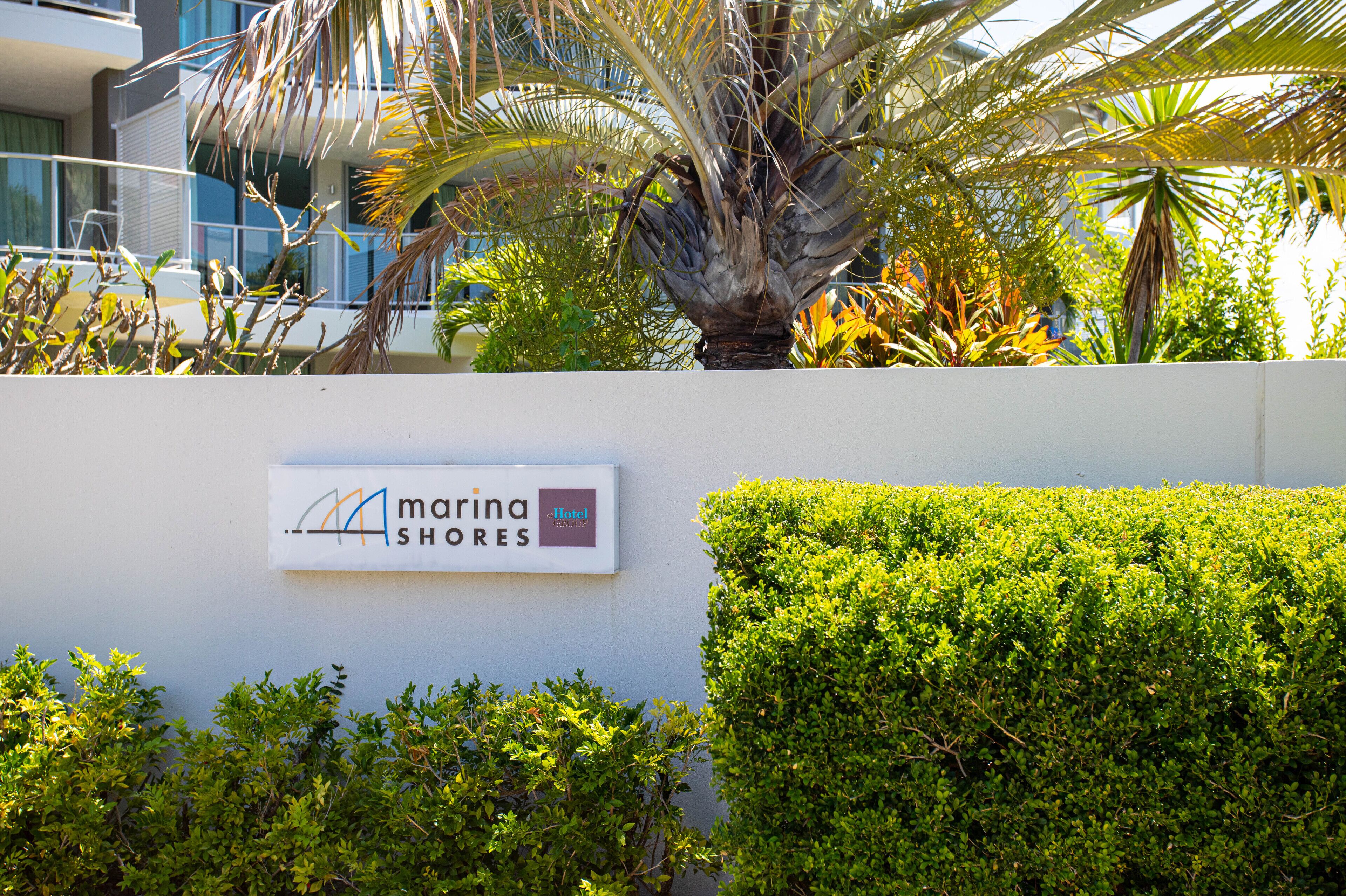 A sign for Marina Shores Hotel.