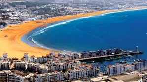 A coastal cityscape with a beach, buildings, and a marina. - Atlantic Palm Beach Aparthotel 5178 (Agadir)
