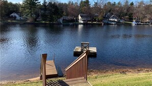 A lake with a wooden dock and a small boat.