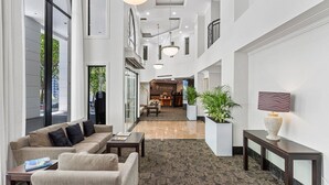 A spacious lobby with a reception desk, seating area, and large windows. - *Pool, spa, two balconies, park views!* (Auckland)