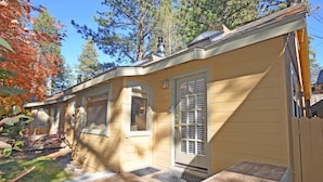 Una casa a un piano con veranda, garage e un piccolo deposito annesso.