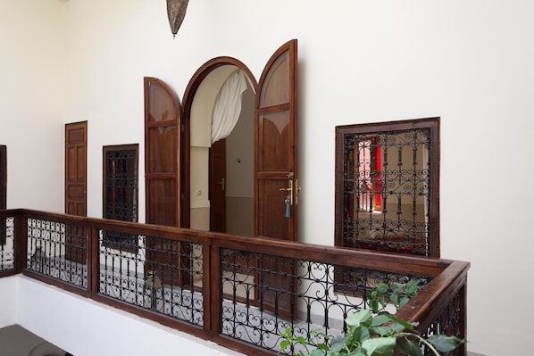 A staircase with a wooden railing and a metal gate. - Riad 34 (Marrakech)