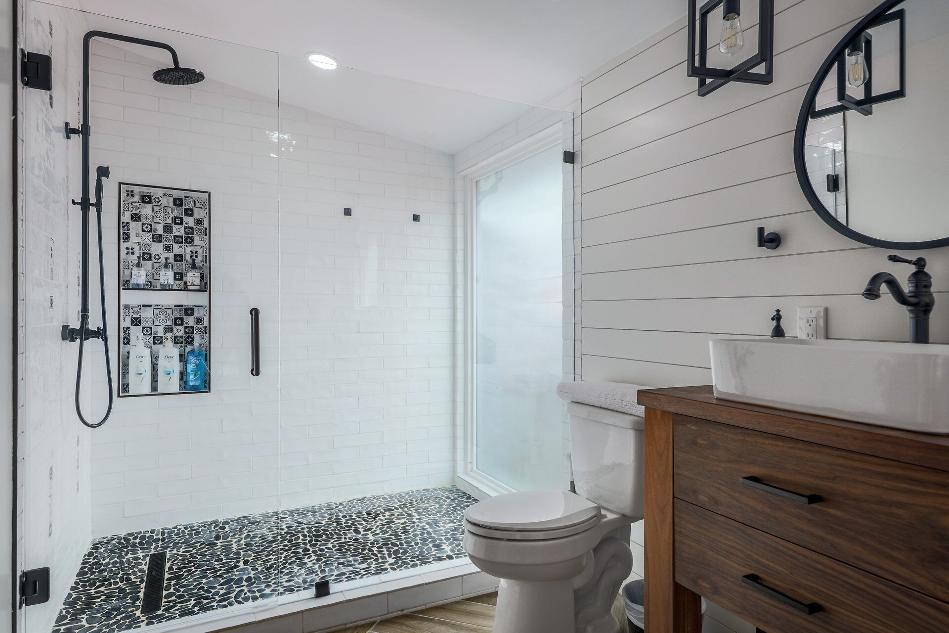 A modern bathroom with a shower, toilet, and vanity.