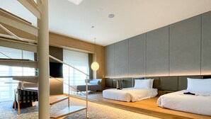 Ein modernes Hotelzimmer mit einem großen Bett, einer Couch, einem Schreibtisch und einer Treppe.