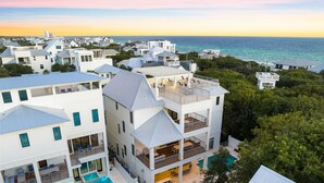 Un resort de varios pisos con piscina, balcones y vistas al océano.
