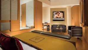 A modern hotel room with a bed, seating area, TV, and wooden furniture. - Bio Hotel Raphael - Relais Chateaux (Rome)