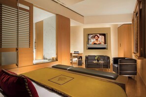 A modern hotel room with a bed, seating area, TV, and wooden furniture. - Bio Hotel Raphael - Relais Chateaux (Rome)