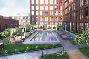 Relax by the pool surrounded by lush greenery and comfortable seating options.